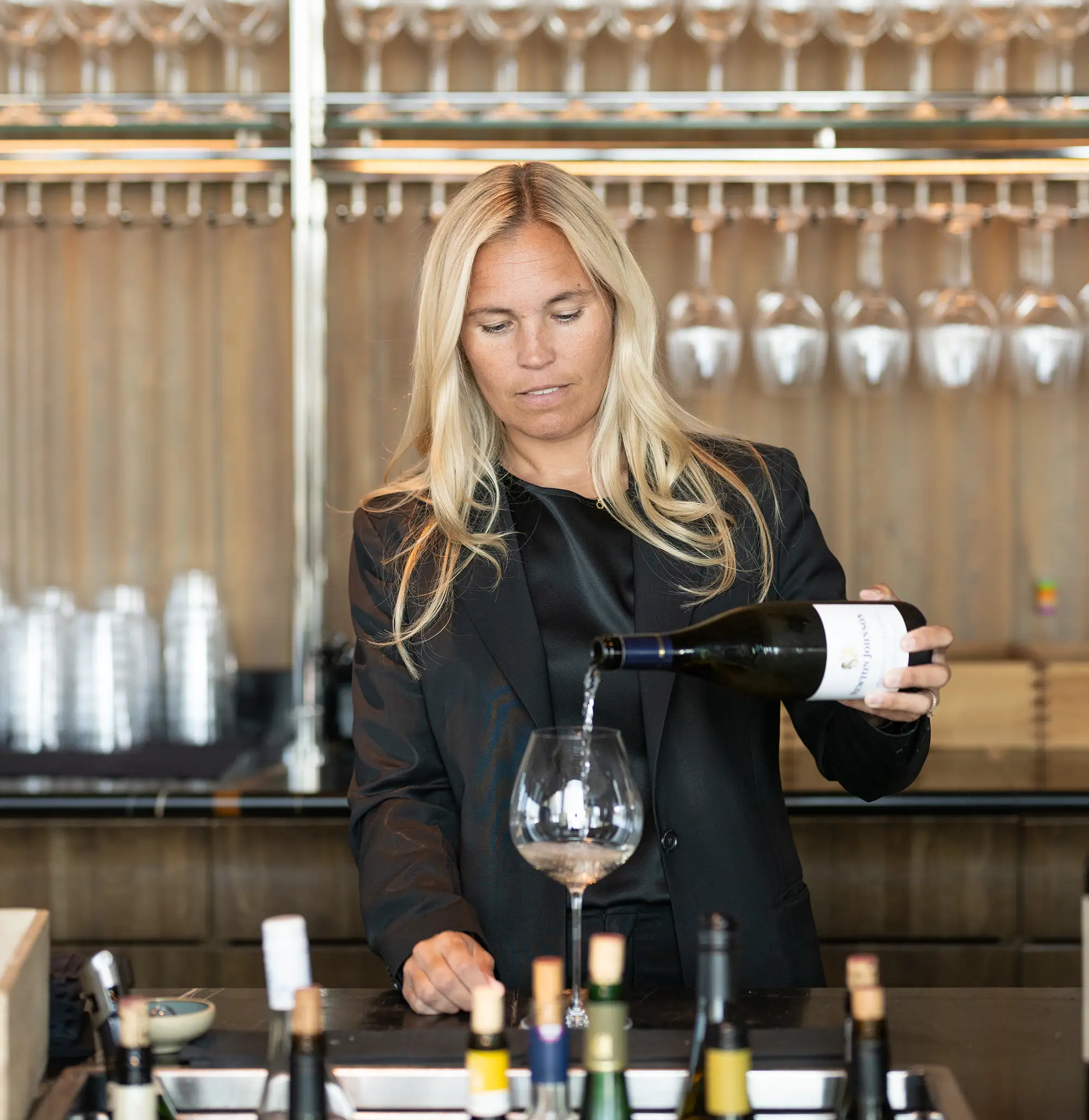 Nyhet på Spesso om gästspel av Winemakers, Janni står och häller upp vin i baren